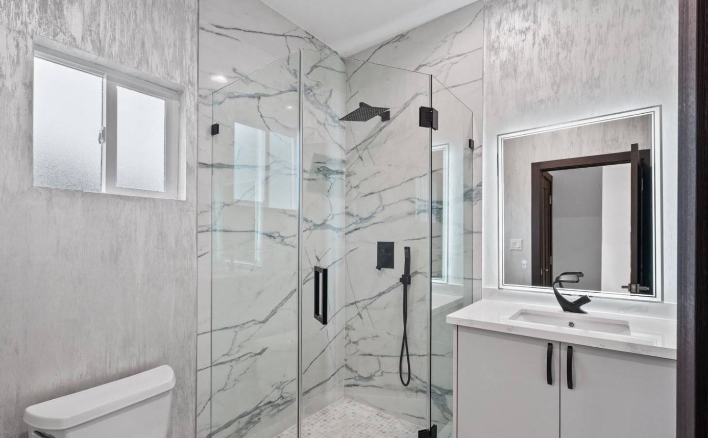 Modern marble bathroom with glass shower and black fixtures